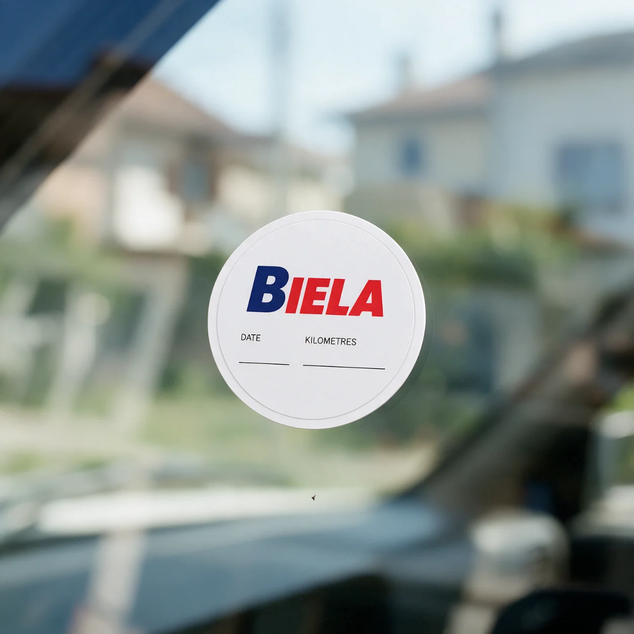 Autocolante de revisão com o logótipo de uma oficina no para-brisas